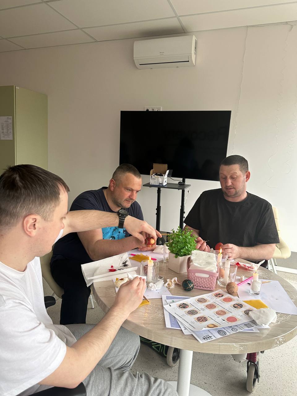 Учасники працюють разом за столом над створенням Великодніх писанок